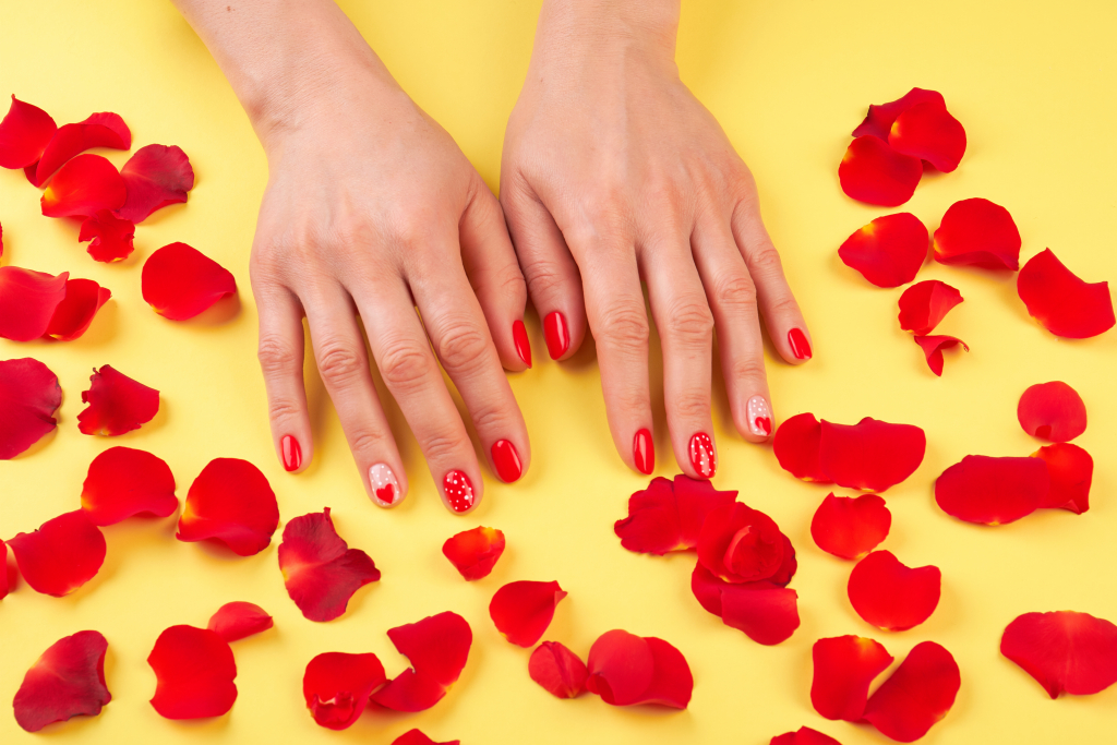 Female manicured hands surrounded with petals
